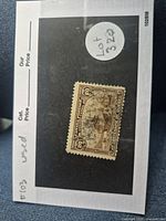 Photo of used 20 cent brown Canadian stamp from 1908 commemorating Jacques Cartier's arrival and Quebec's 300th anniversary, showing the full stamp with visible printed details and postmark marks.