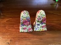 Front and back view of two floral chintz salt and pepper shakers showing colorful flower patterns
