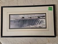 Frontal view of framed panoramic photograph showing Niagara Falls with black frame and white matting.