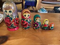 Front view of the 5 Russian nesting dolls showing detailed facial features and floral designs.