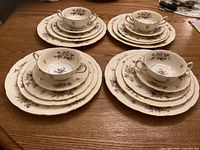 Full set arranged on wood table showing plates stacked and cups placed on top