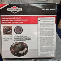 Box showing Briggs & Stratton logo, product name, and description noting features like dual high-pressure water jets and quick-connect spray wand attachment.