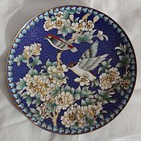 Front view of blue cloisonné plate with birds on blossoms design, showing detailed enamel work with no chips or cracks.