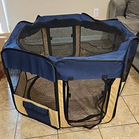 Full view of the EliteField soft pet playpen showing hexagonal shape, navy blue and beige fabric with mesh sides and fully open top.