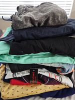 Stack of assorted men's shirts in different colors and patterns.