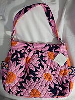 Front view of Vera Bradley pink floral quilted purse showing the handle, side pocket, and attached tag.