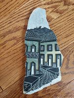 Stone slab artwork showing building facade street scene from front view.