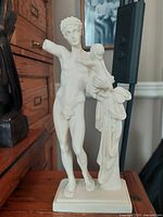 Photo of vintage alabaster sculpture of Ermes, showing front view with missing right arm and child figure on pillar.