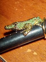 Close-up photo showing the crocodile design with green and black crystals in gold tone metal ring