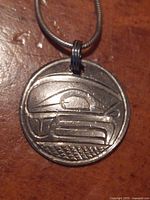 Close-up front view of round Thunderbird pendant in 925 silver, showing traditional engraving pattern.