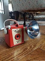 Camera front view with flash attached on hardwood floor