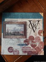 Front of the decorative box showing historical painting, VOC logo, text in Dutch referring to 5 VOC Daalders commemorative to the Dutch East India Company.