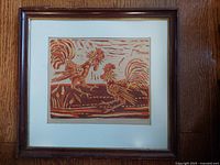 Framed vintage print showing two roosters in warm earth tones, matted and in wood frame under glass.