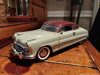 Front quarter view showing cream body and root beer colored roof with chrome bumper and grille details.