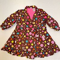 Front view showing colorful Minnie Mouse patterned girl's jacket with ruffled bottom and pink lining.