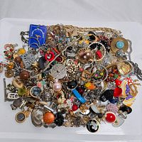 Top view of tray with mixed assorted costume and estate jewelry pieces, showing variety of metals, colors, and styles