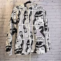 Front view of hooded zippered hoodie with black and white comic strip pattern depicting a woman and man with captions about skateboarding.