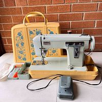 Brother Charger 1681 sewing machine mounted in yellow carrying case with accessories tray open, foot pedal in foreground