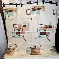 Full view of mid century modern fabric showing the repeating abstract geometric pattern with browns, teal, beige and black on a cream background