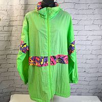 Front view of neon green windbreaker jacket with patterned bands around waist and elbows, full zip front closure.