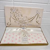 Boxed set of two sealed white pillowcases with pink French tulip embroidery in combed percale, tied with white satin ribbon inside marked Dan River Combed Percales.