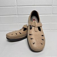 Side angle showing tan color, cut-out details, strap and low sole