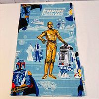 Folded vintage Star Wars Empire Strikes Back twin sheet showing characters C-3PO, R2-D2, Boba Fett, and background elements like Star Destroyers and snow terrain.