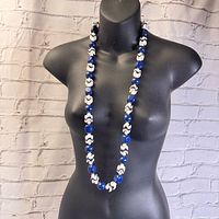Necklace displayed on a black mannequin bust, showing full length and design of blue and white chunky beads.