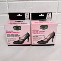 Two boxes of women's Moneysworth & Best High Heel Rubber Overshoes size 3 brand new in pink and black packaging with product image and details.