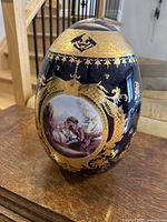 Front view of one vase showing gold gilt and hand-painted romantic couple medallion