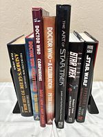 Photo of the spines of seven books showing titles related to Star Wars, Star Trek, Doctor Who, and Isaac Asimov's Guide to the Bible.