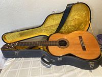 Full view of guitar in open hardshell case showing overall condition and included case