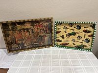 Two rectangular wooden serving trays on table, one with classic hunting scene and beige border, the other with garden tools and green border
