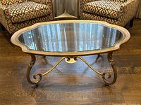 Oval glass top with scalloped metal rim viewed from front