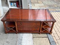 Front angle view showing two drawers, side shelves with metal cross braces, missing drawer pulls and a piece of metal shelf trim.