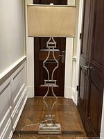 Full view of lamp showing painted metal base with geometric design and rectangular fabric shade.