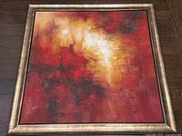 Full front view of framed abstract painting on wooden floor
