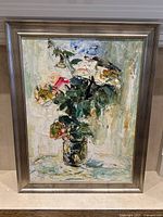 Frontal image of the large oil painting framed, showing a floral still life with thick textured brushstrokes, signed on bottom right.