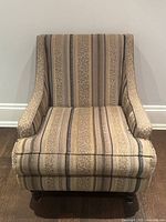 Front view of the vintage upholstered lounge chair showing striped and animal print fabric upholstery and cushioned seat.