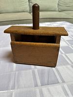 Front view of wooden mould box showing open top and vertical handle