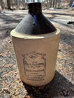Front view of the antique stoneware jug showing branding and glaze