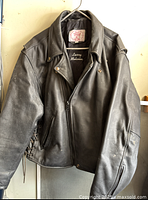 Front view of black leather motorcycle jacket with zipper and lace-up sides