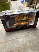 Full boxed packaging showing the New Bright Power Horse remote control bulldozer and included accessories such as remote control and traffic cones.