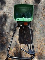Top view of green hopper and handle control lever showing overall condition and design of seed spreader.