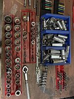 Red racks of shallow sockets and blue bins of deep sockets on workbench
