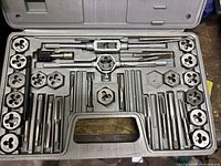 Top-down photo showing 40-piece tap and die set neatly organized in gray plastic case.