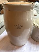 Large beige stoneware crock with crown and number 8 marking, showing side profile with lid in place.