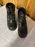 Front view of both boots on table showing black leather, laces, and general shape.