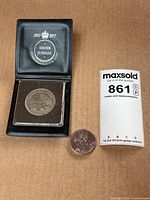 Two coins: one in a protective case labeled 1952-1977 Silver Jubilee Commemorative Coin Bailiwick of Jersey 25 pence, and one loose coin.