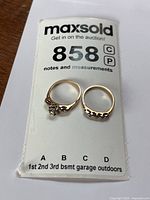 Engagement ring and wedding band displayed on auction card